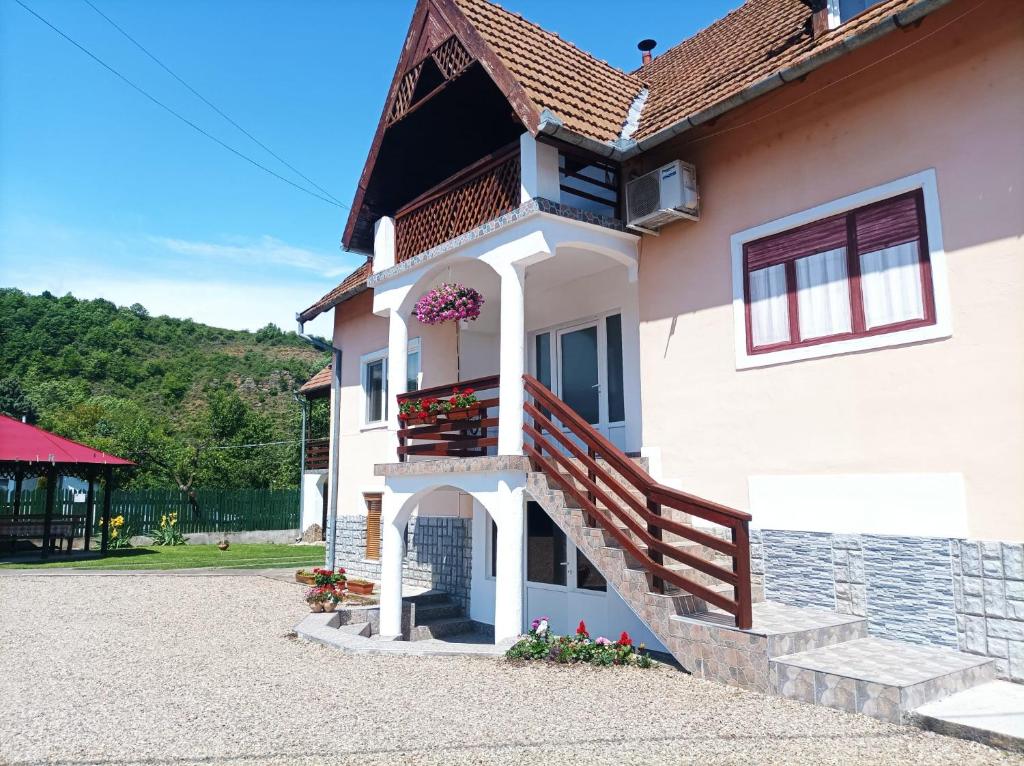 una casa con scale e un balcone fiorito di Pensiunea CORIMEN Vadu Crisului a Vadu Crişului