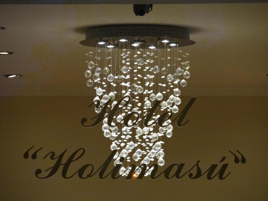una lámpara de araña colgando del techo en una habitación en Hotel Holimasú en Colón