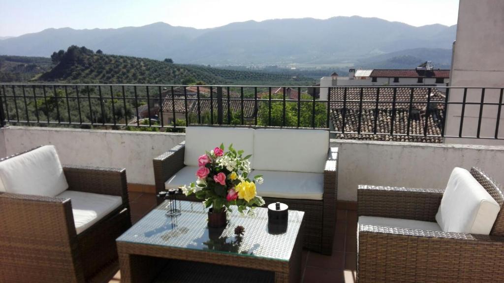 una mesa con un jarrón de flores en el balcón en Alojamiento Turistico Rural El Yelmo, en Segura de la Sierra