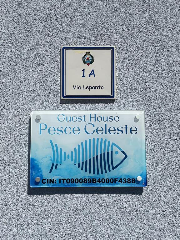 a sign for a guest house and a fish on a wall at Guest House Pesce Celeste in Stintino