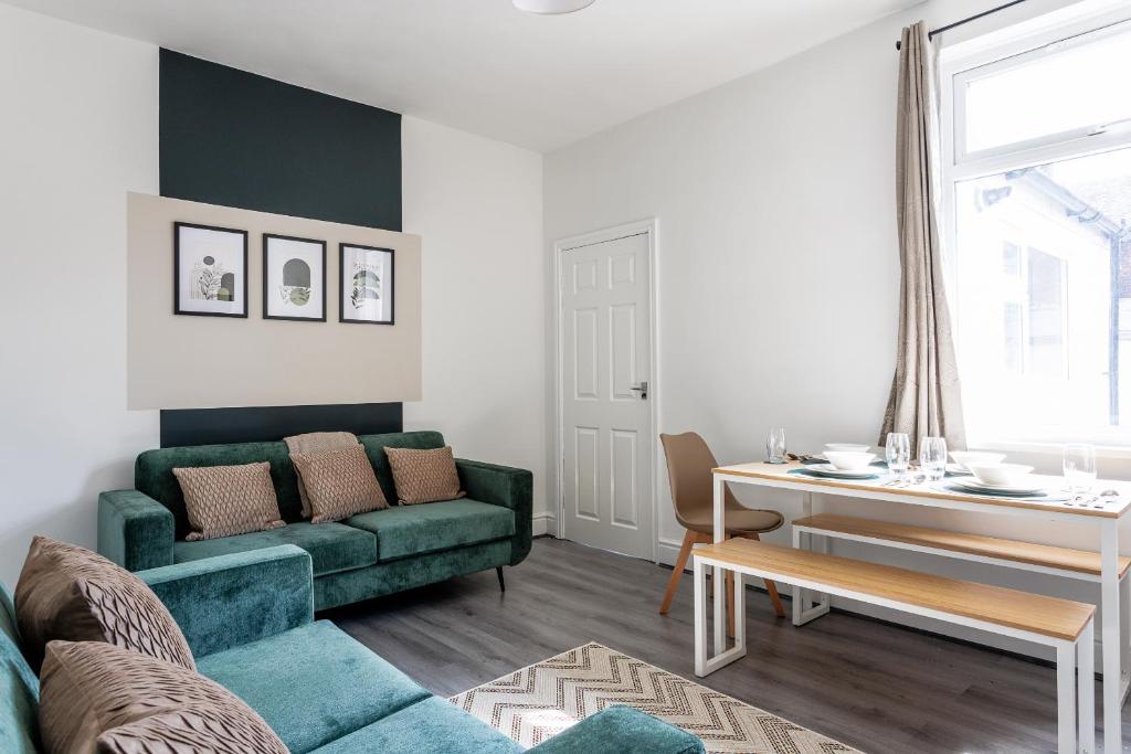 Una sala de estar con un sofá verde y una mesa. en Central Darlington 3 Bedroom Home, en Darlington