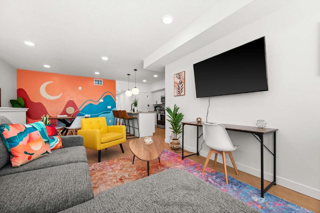 a living room with a couch and a tv on a wall at SLC Townhome 2BR Mountain Views Garage in Salt Lake City