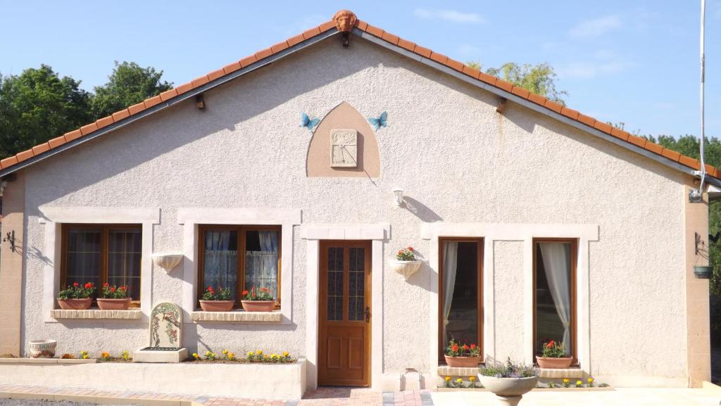 a white house with windows and a door at Gite et Studio "A l'accueil des Papillons" in Courrières