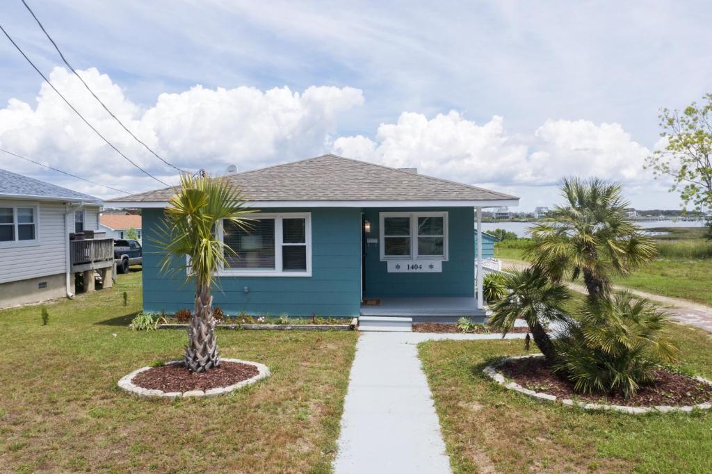 a blue house with palm trees in front of it at Bay Breeze Retreat in Morehead City