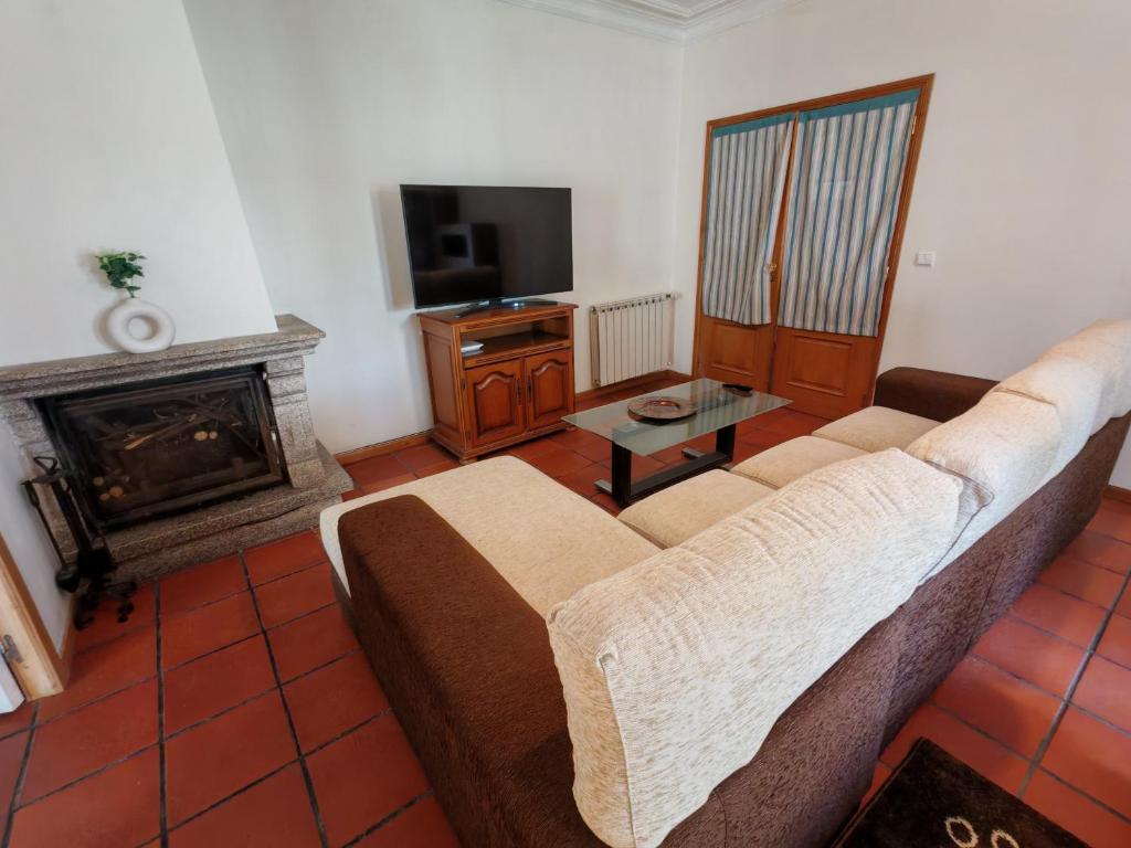 Una sala de estar con un sofá y una chimenea. en Casa Jugueiros, en Viseu