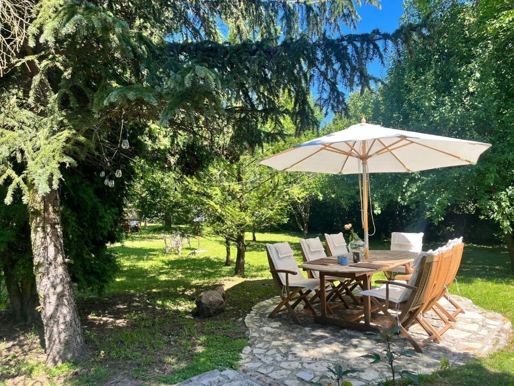 a wooden table and chairs with an umbrella at Dom Verte z ogrodem na Jurze in Turów Celiny