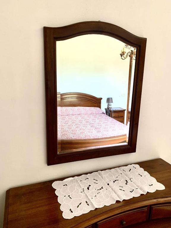 a mirror on a wall above a wooden table at Cascina Nuova in Mombasiglio