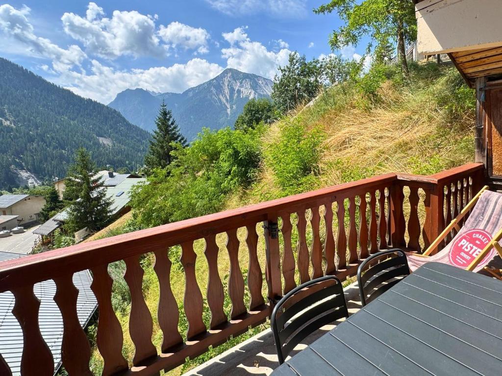 d'une table sur un balcon avec vue sur les montagnes. dans l'établissement L’Éterlou Au pied des pistes, vue montagne, à Champagny-en-Vanoise