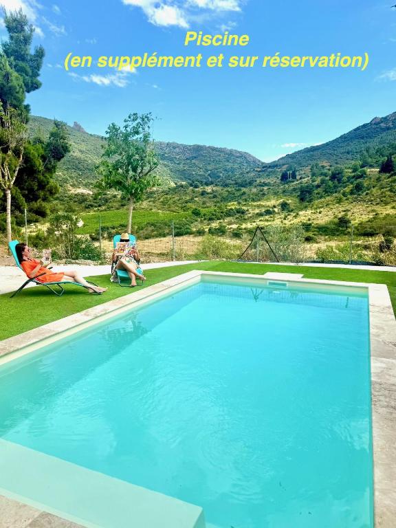 une femme assise sur une chaise à côté d'une piscine dans l'établissement Studio les trois chemins, à Cucugnan
