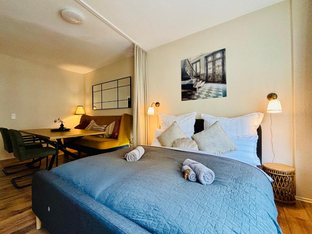 a bedroom with a blue bed with two towels on it at AyCatcherHomes - Top Lage I 4 Personen I 2 Schlafzimmer I Zentral I Altstadt Marburg I Nähe Fluss Lahn I WLAN I Boutique App CHIRON in Marburg an der Lahn