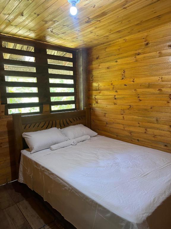 a bedroom with a bed in a wooden wall at Ibiza beach in Moñitos
