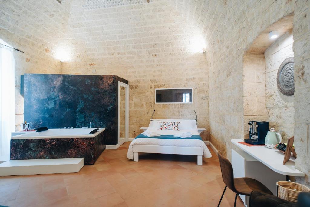 a bedroom with a bed and a tub and a sink at Bue Marino Suites - Exclusive stay with Castle view in Bisceglie