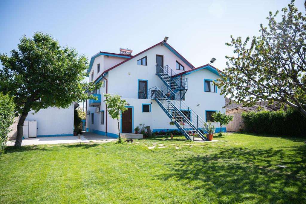 a white house with a spiral staircase in a yard at Casa Lebăda in Jurilovca