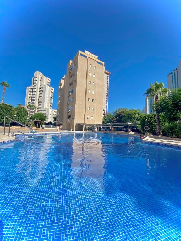 a large swimming pool in front of a tall building at Apartamentos Finestrat I-II in Cala de Finestrat