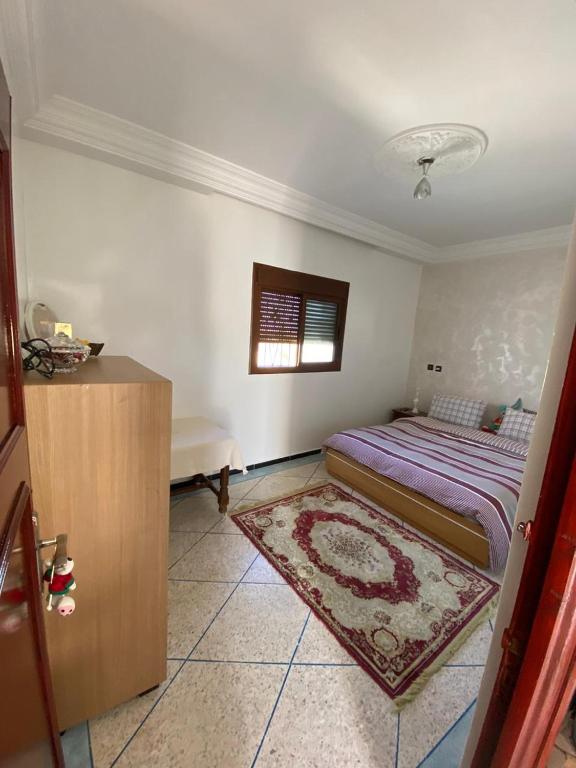 a bedroom with a bed and a rug at Yahya oulidia in Oualidia