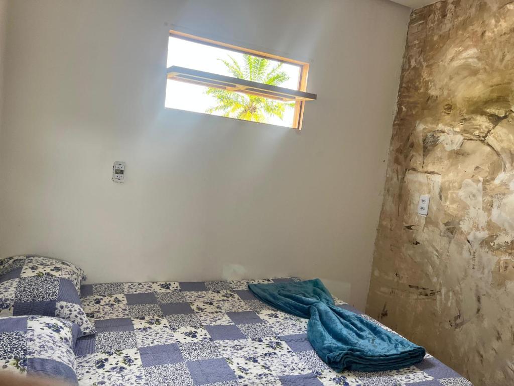 un dormitorio con una cama y una ventana en Casa da Tetinha, en Lençóis