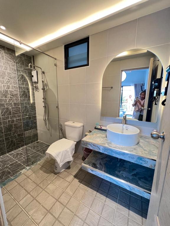 a bathroom with a sink and a shower and a toilet at Two Tree Cafe At Suanmuangthong 