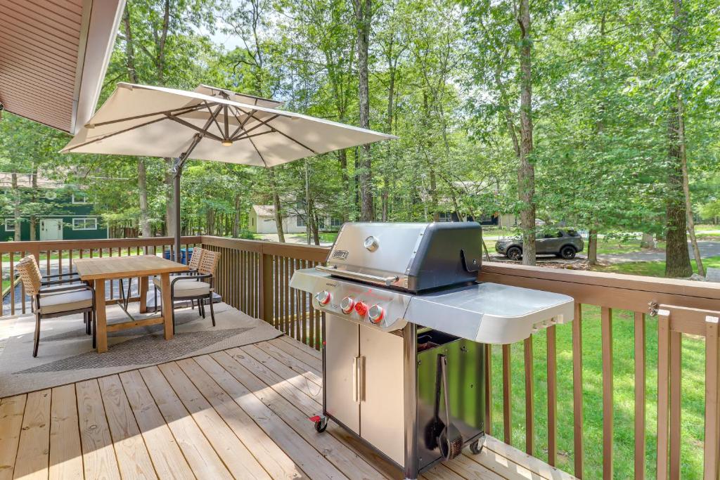 un grill su un ponte con tavolo e ombrellone di Pool and Lake Access, Yard Poconos Family Getaway a East Stroudsburg