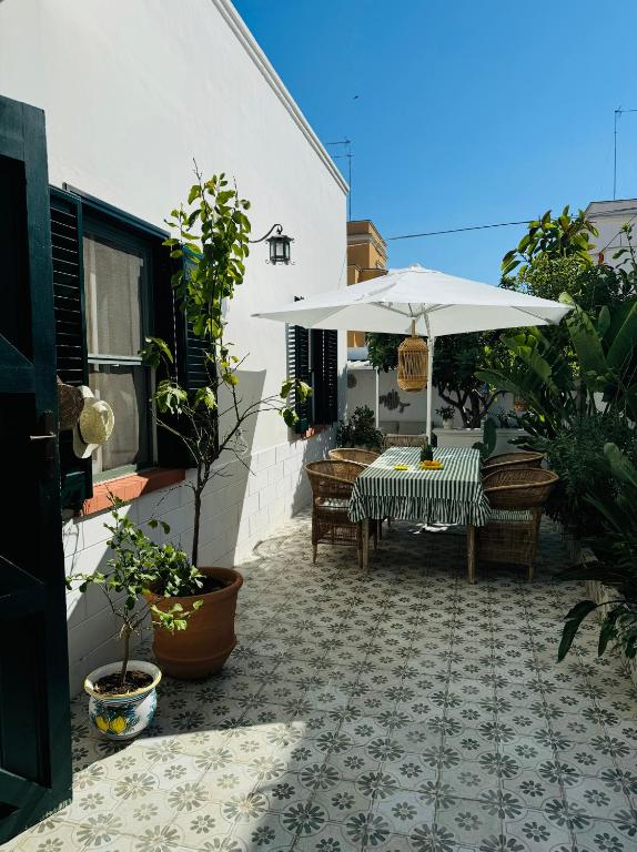 a patio with an umbrella and a table and chairs at Casa Sasa in Porto Cesareo
