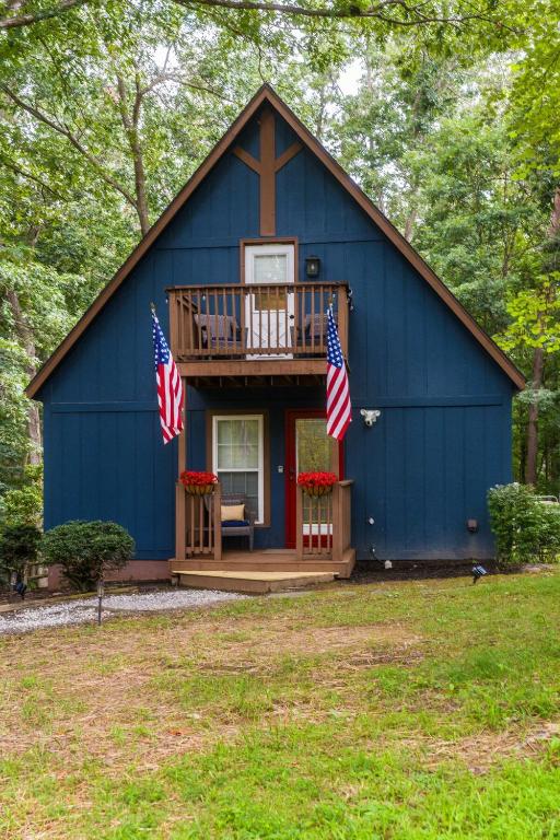 a blue house with two american flags in front of it at Adventures on Alleghany in McGaheysville