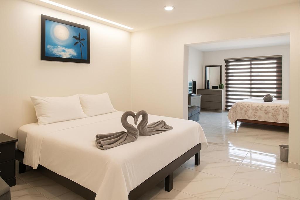 a bedroom with a bed with a bow on it at Sunset Suites Mazatlán at Lomas de Mazatlán in Mazatlán