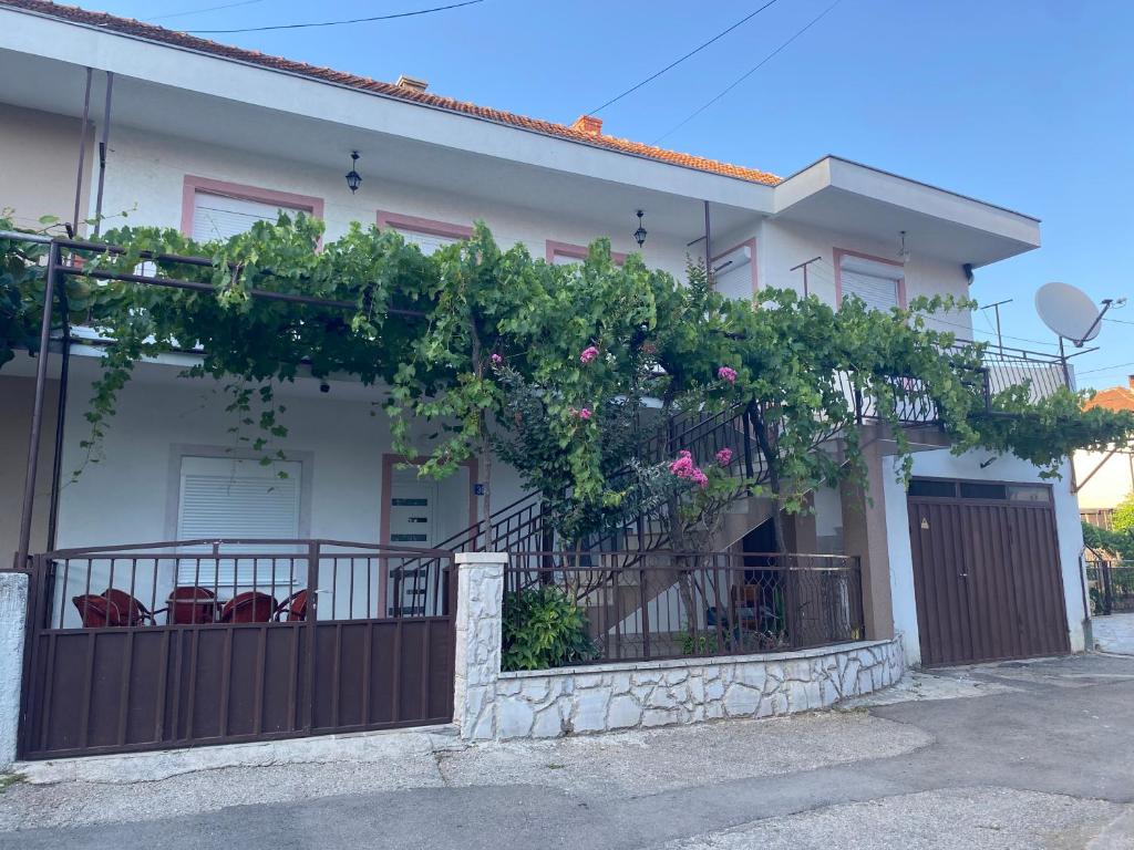 a house with a fence with flowers on it at Apartman LENA in Trebinje