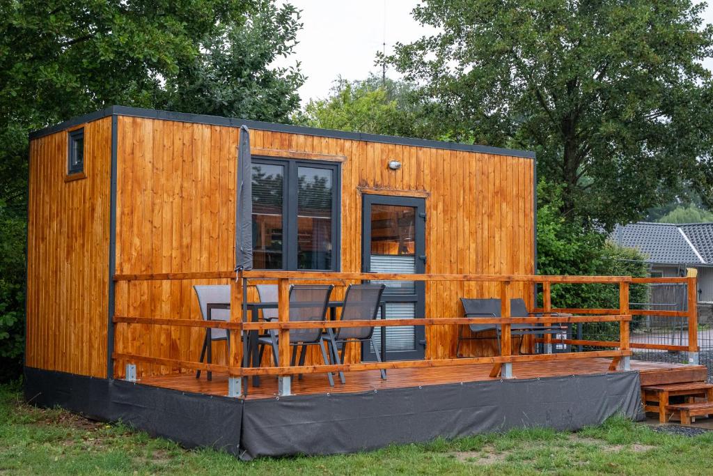 a wooden cabin with chairs and a deck at Tiny Häuser am Steinhuder Meer in Wunstorf