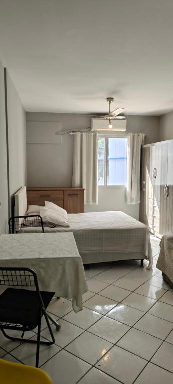 a bedroom with a bed and a chair and a window at Studio Centro Floripa 02 in Florianópolis