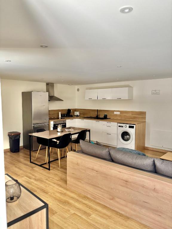 Una cocina y una sala de estar con un sofá y una mesa. en Appartement plein coeur village, en Étoile-sur-Rhône