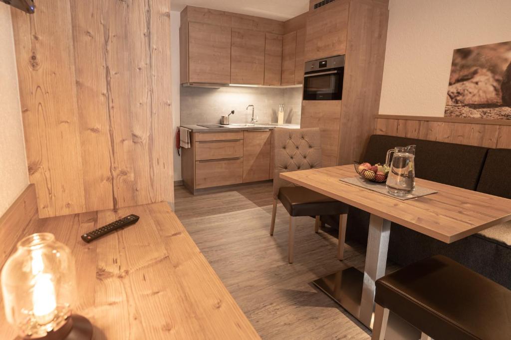 una cucina con un tavolo di legno e una sala da pranzo di Senner Appartements a Umhausen