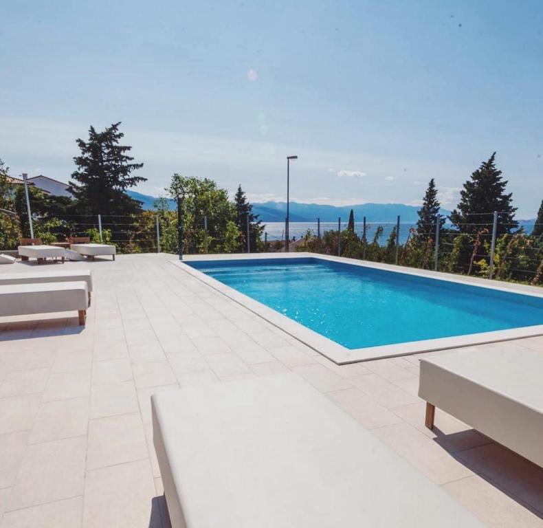 a swimming pool in a yard with tables and chairs at Villa Angel Dalia in Novi Vinodolski