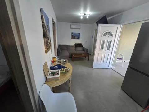 een woonkamer met een bank, een tafel en een deur bij uncie spiros house in Nea Fokea
