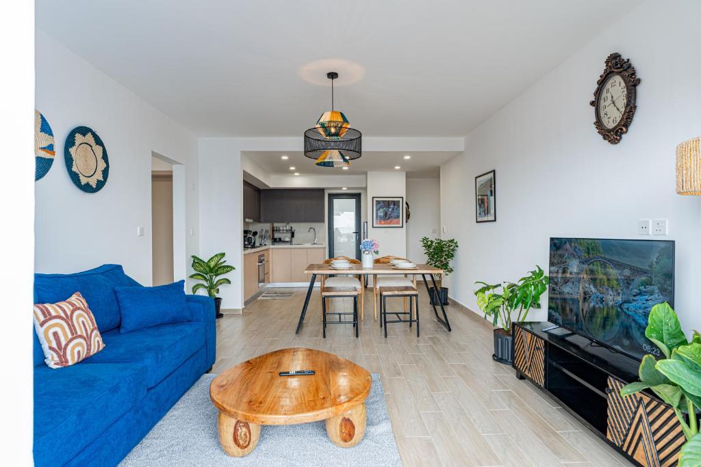 a living room with a blue couch and a table at Mombasa Road SouthPark 2 bedroom Spacious Apartments with National Park View in Nairobi