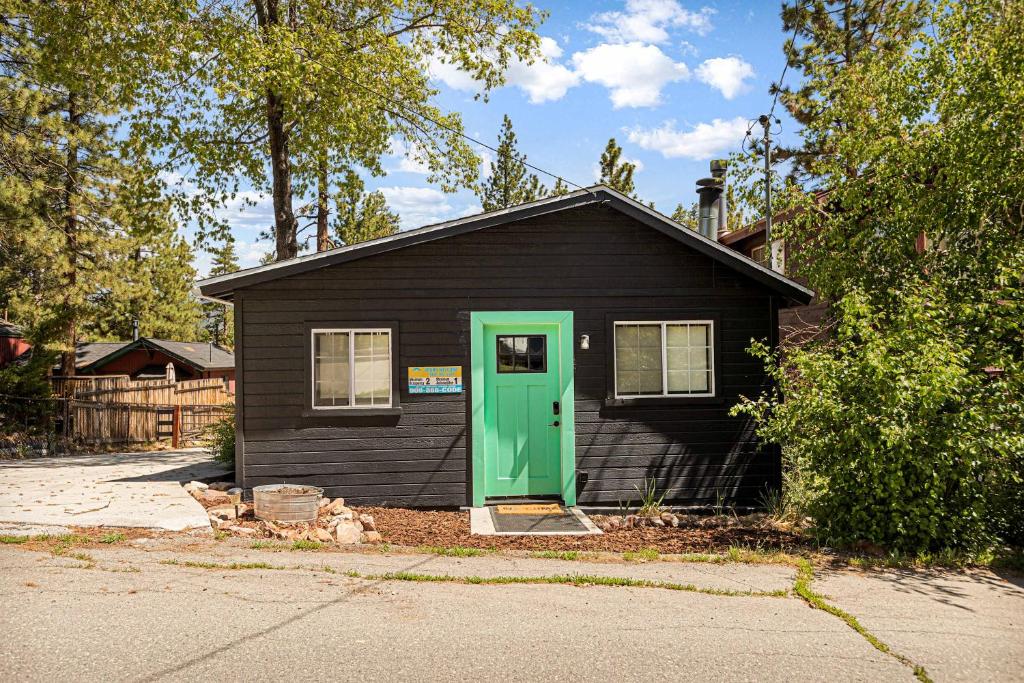 ein kleines schwarzes Haus mit grüner Tür in der Unterkunft Into the Woods Bungalow - Romantic Vacation in Big Bear Lake