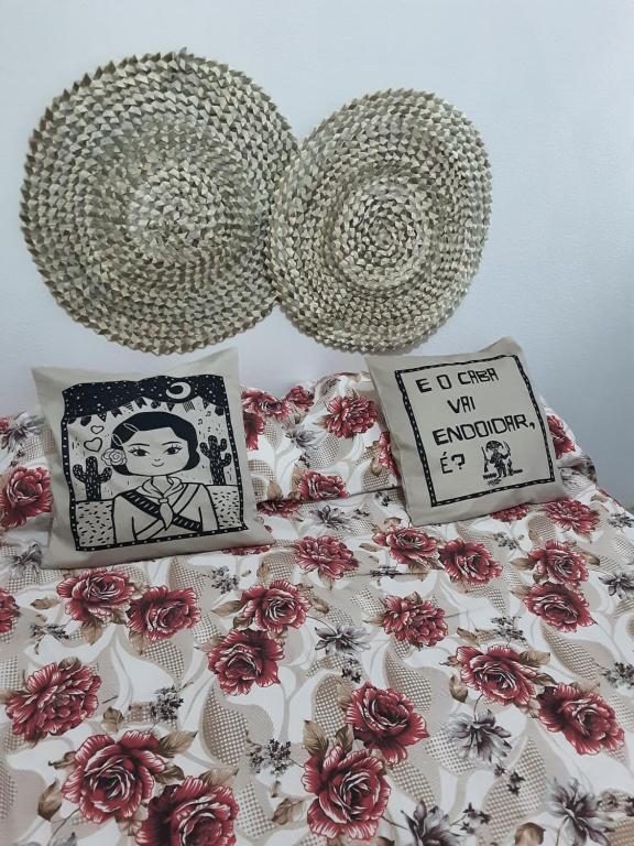 a bed with a comforter with flowers on it at apartamento completo simples 5 minutos do moda center in Santa Cruz do Capibaribe