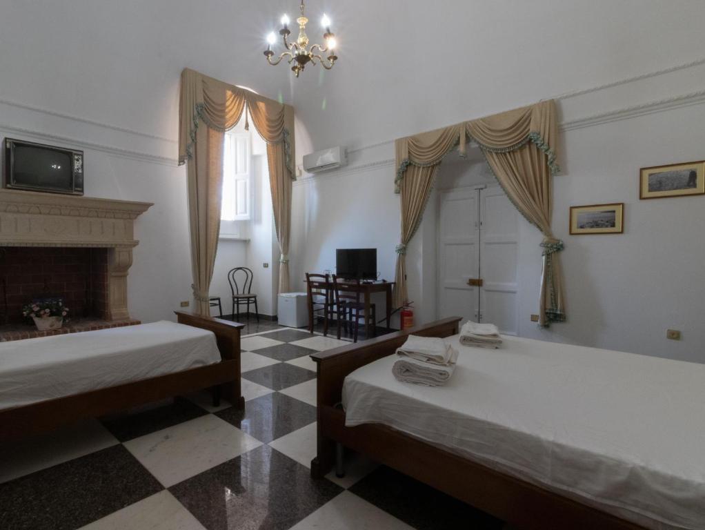 a bedroom with two beds and a fireplace at 100 Craste in Ugento