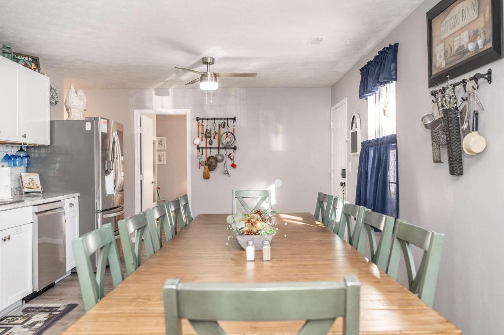 a dining room with a long table and green chairs at Arkstone Retreat 3 in Williamstown