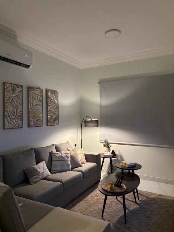 アル・コバールにあるشقة مودرن دخول ذاتيのソファとテーブル2つがあるリビングルーム