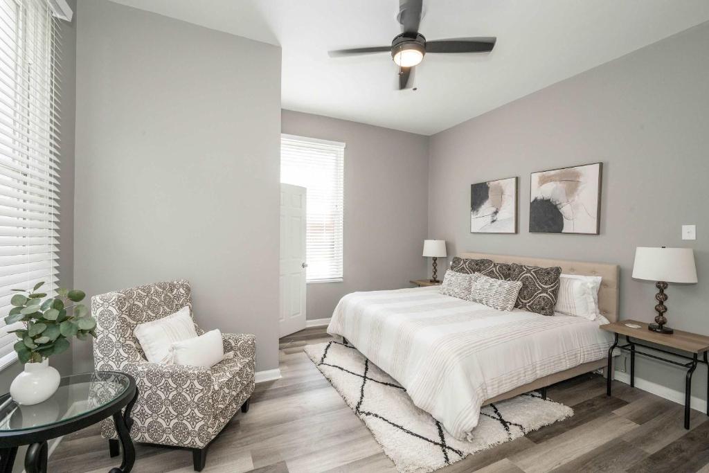a bedroom with a bed and a chair and a ceiling fan at Queen City Grand House in Cincinnati