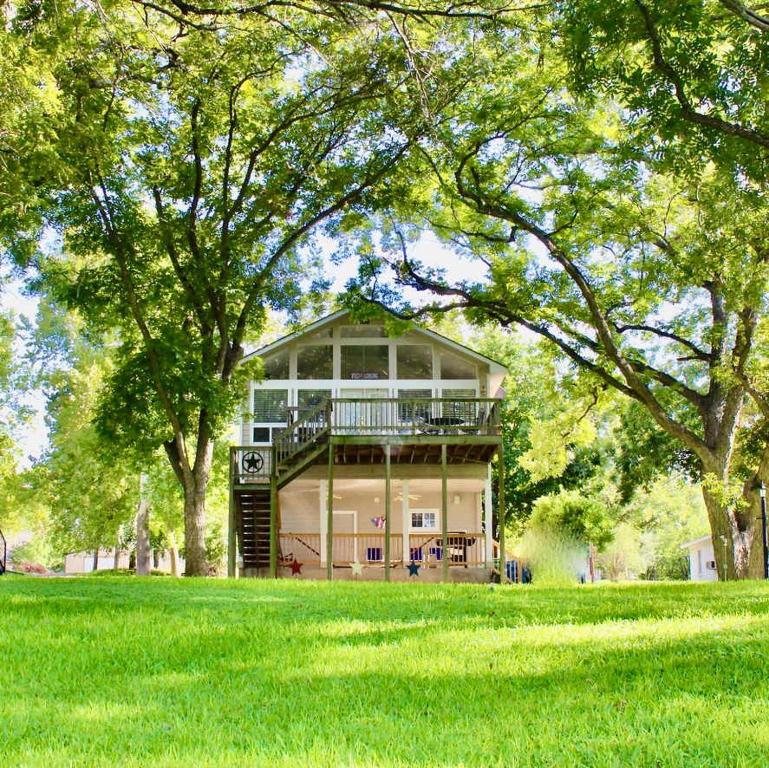 a large building in the middle of a grass field at Pet Friendly Retreat on Lake LBJ in Burnet