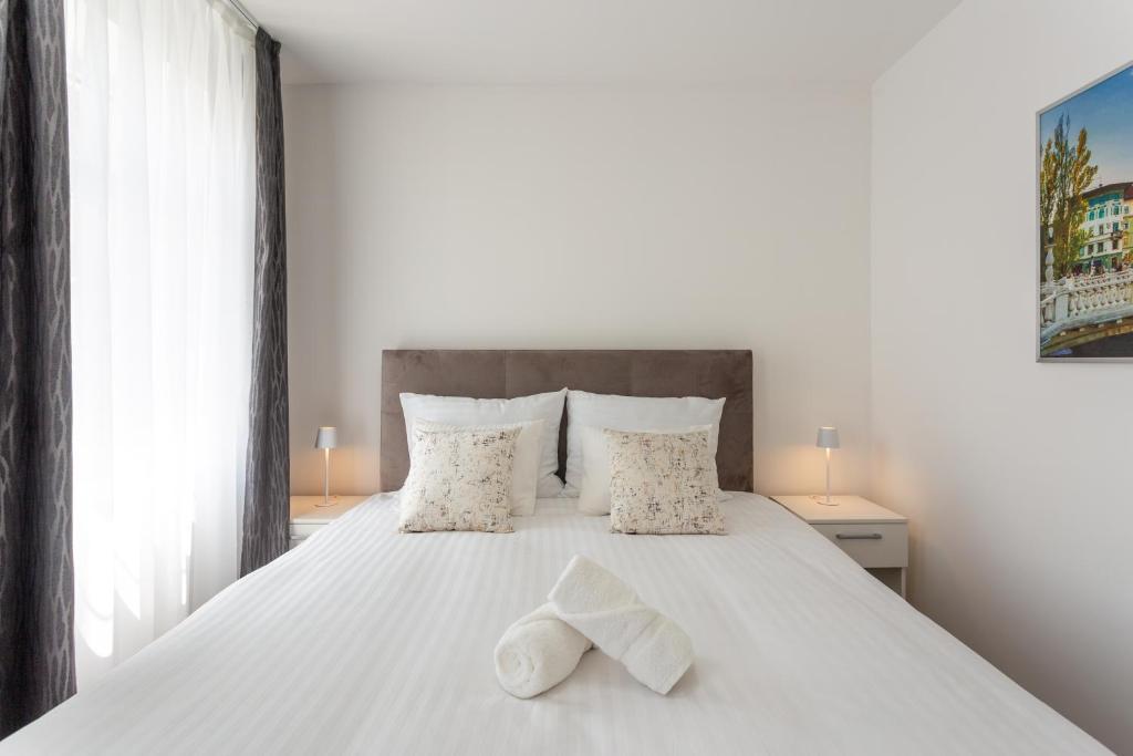 a bedroom with a white bed with two towels on it at Vila Slovenka in Celje