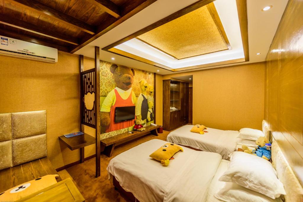 a room with two beds and a painting of a bear at Mount Emei Teddy Bear Hotel玩具熊酒店 in Emeishan City