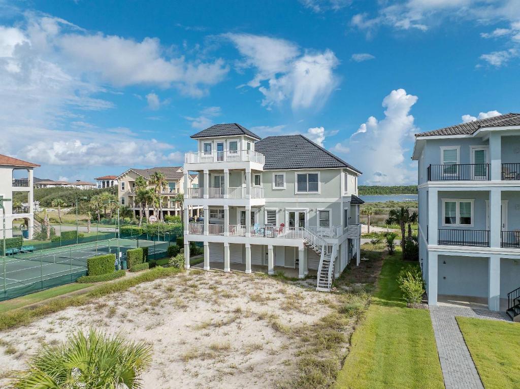 an aerial view of a white house with a tennis court at Beach Access with Elevator & FREE Activities in Gulf Shores
