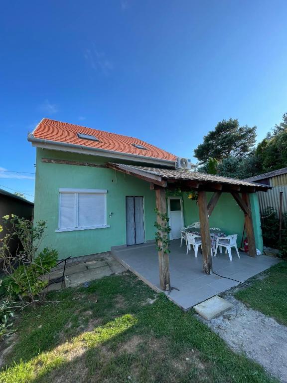 une serre avec une terrasse et une table dans l'établissement Green Gables, à Zalakaros