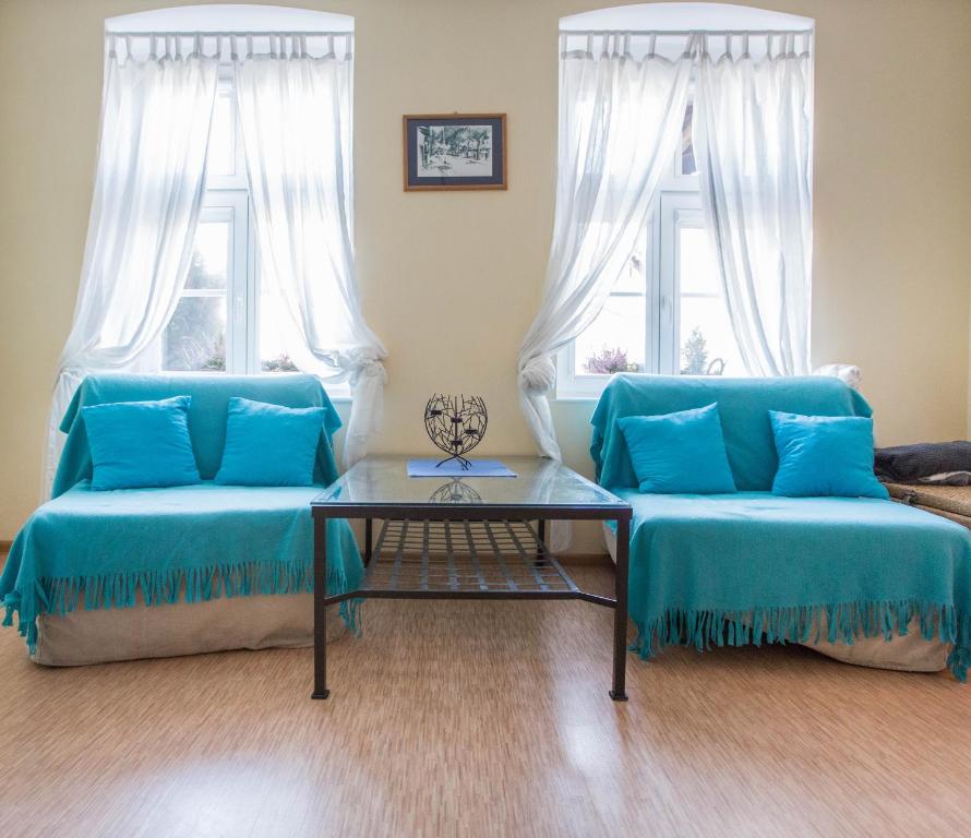 a living room with two blue couches and a table at Apartament Plaża in Gdańsk