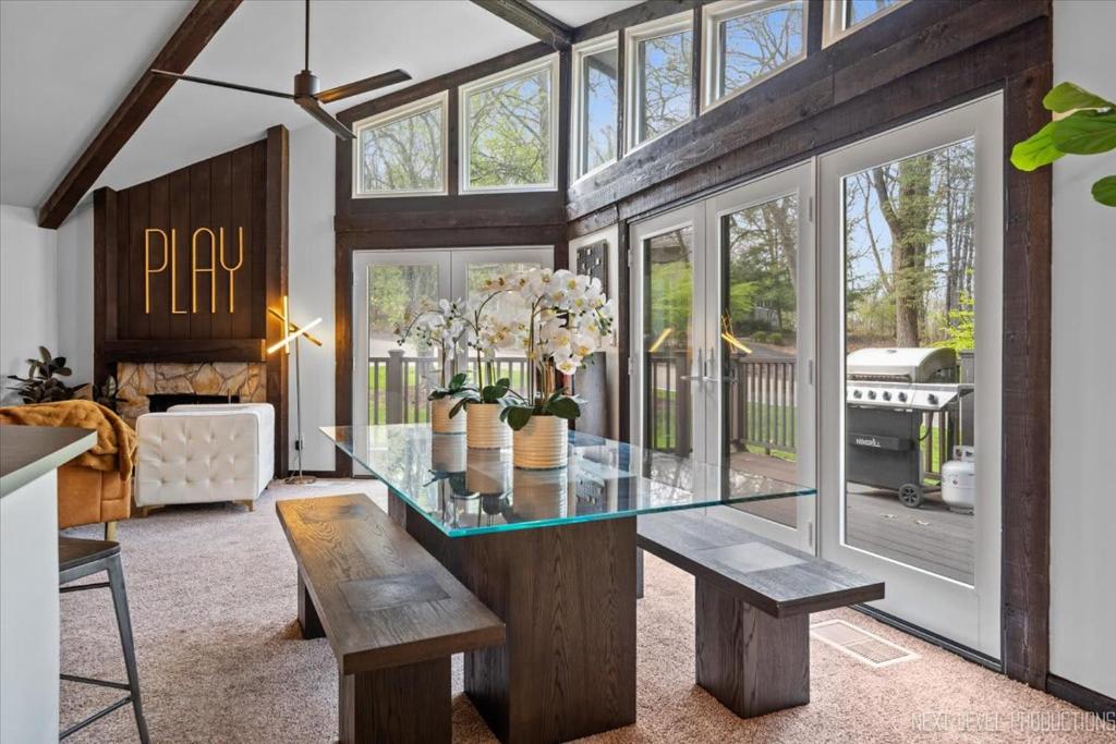 a dining room with a glass table and a couch at Game Lovers Getaway In Abbey Springs with Golf Cart in Lake Geneva
