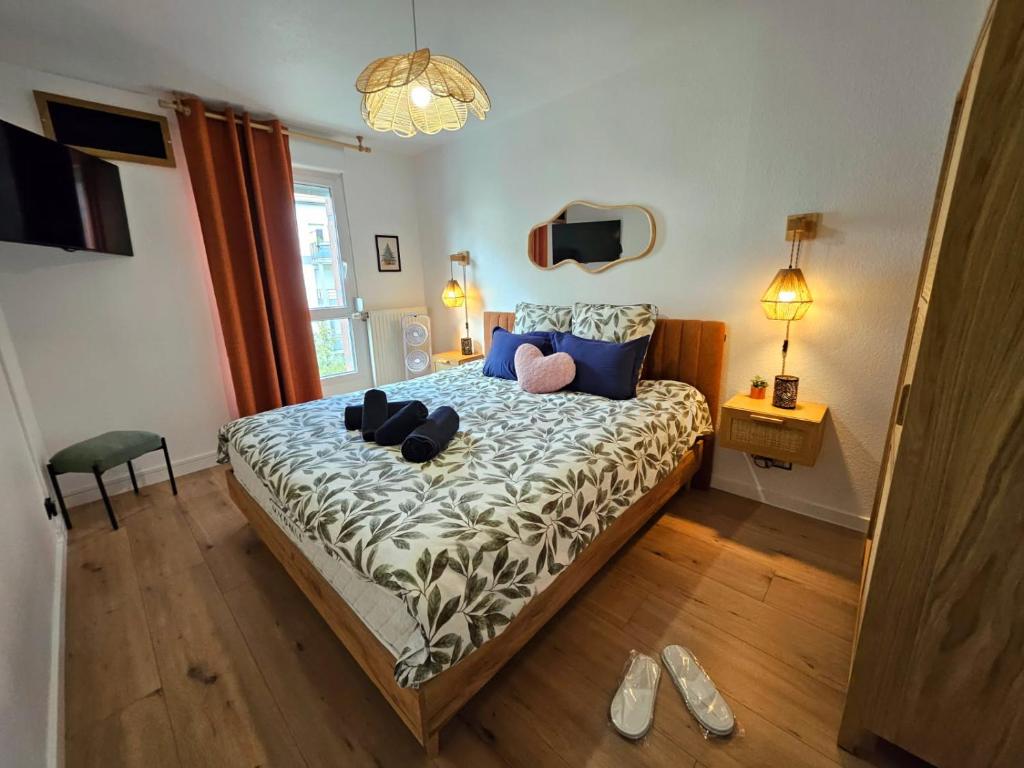 Hotel Gîte Forestier - T2 Cosy avec Terrasse & Parking privatif -Centre ville, a bedroom with a bed with shoes on it at Gîte Forestier - T2 Cosy avec Terrasse & Parking privatif -Centre ville in Colmar