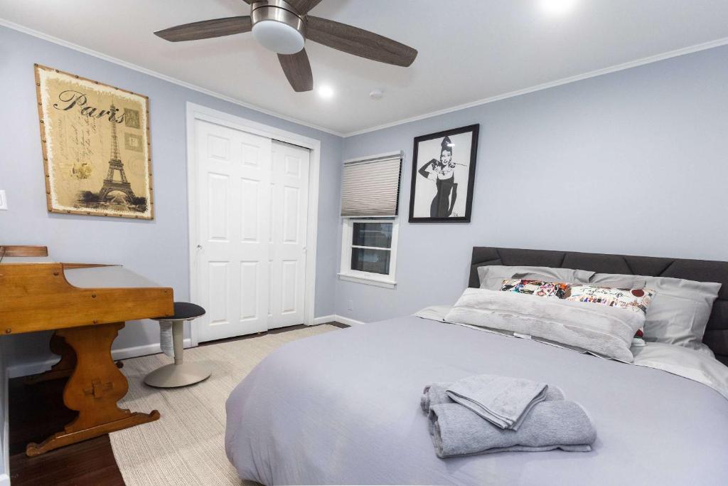 a bedroom with a bed with a ceiling fan and a piano at Chic Downtown Lake Geneva Apartment - Sleeps 2 in Lake Geneva