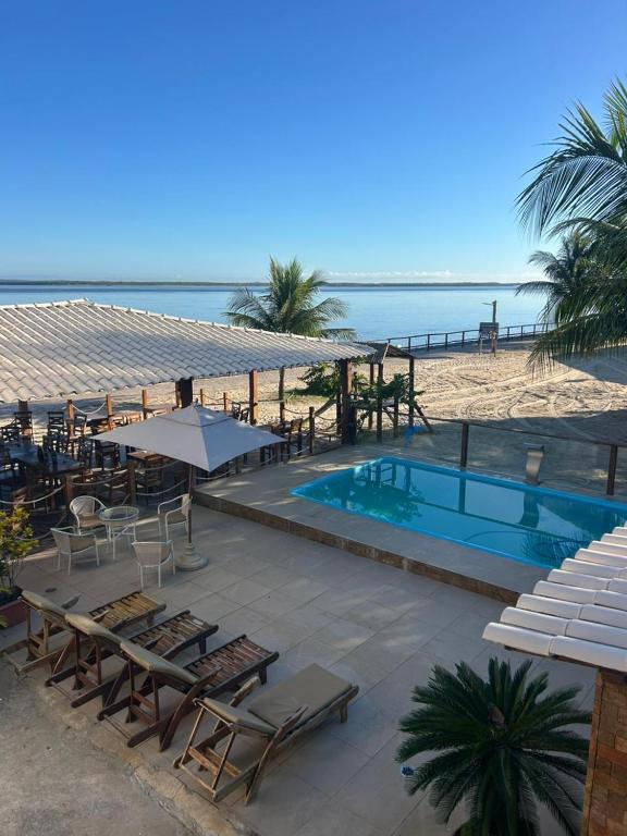 a resort with a swimming pool next to the beach at Pousada Algas Marinhas in Mangue Sêco