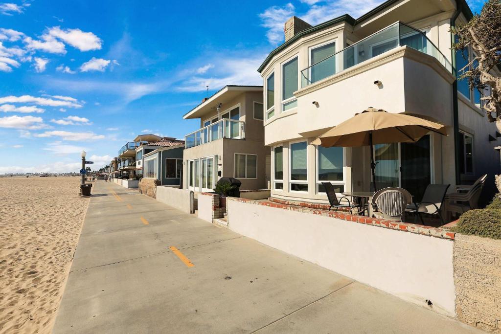 a house on the beach with an umbrella at Seashore Sun and Fun - On Beach in Newport Beach